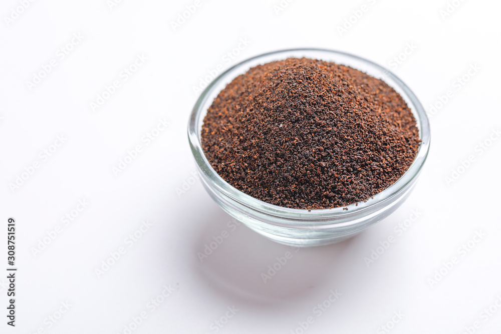 Dry black tea in glass bowl over white background Dry black tea in glass bowl over white background