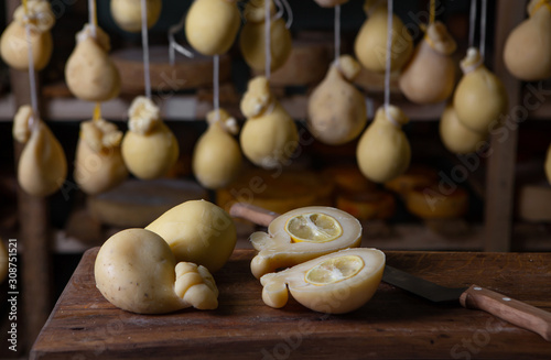 Sliced head of Italian hard cheese Scamorza or Caciocavallo with lime. caciocavallo - Italian cheese made from cow's or sheep's milk, closeup.