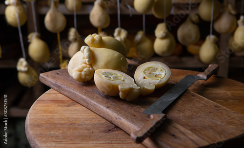 Sliced head of Italian hard cheese Scamorza or Caciocavallo with lime. caciocavallo - Italian cheese made from cow's or sheep's milk, closeup.
