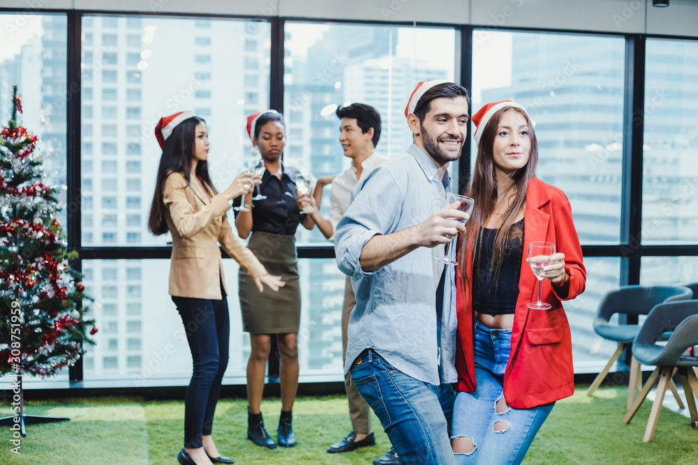 Obraz premium Couple office workers celebrating with drink wine together in the company.