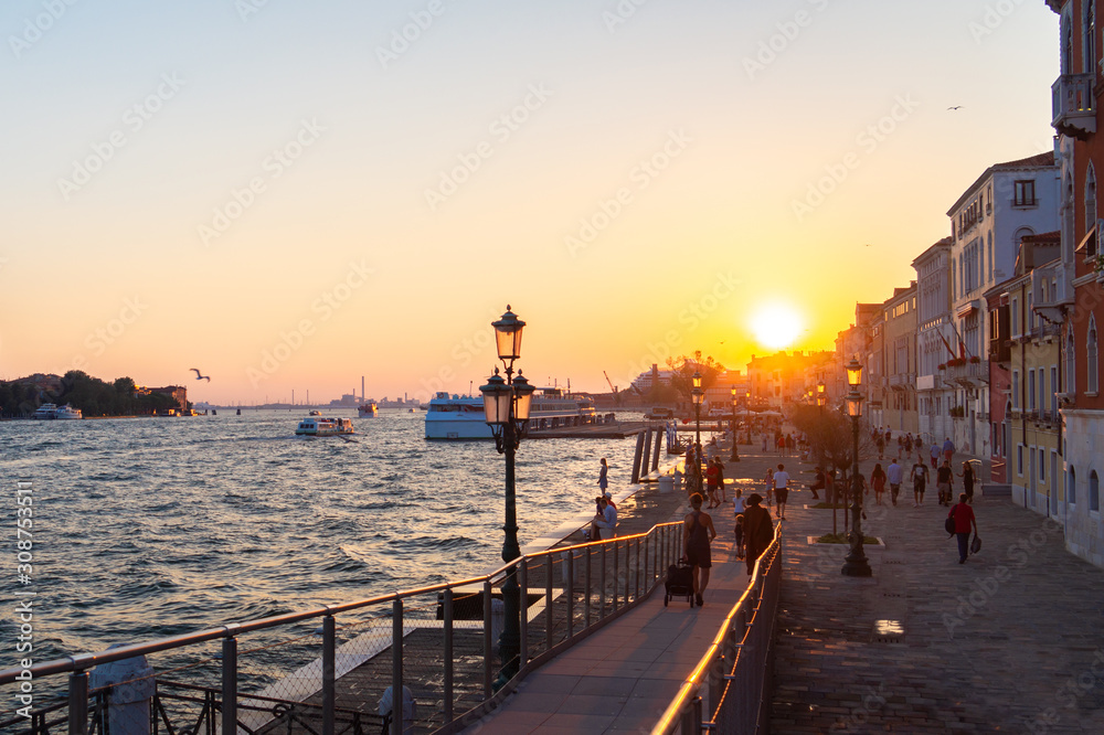 Venice, Italy. Tourists on the embankment at sunset