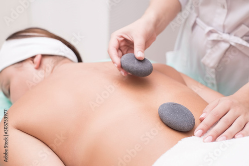 Portrait of a young woman blissfully enjoying spa therapy. close-up. Massage stones