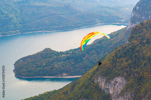 A paraglider flies over Molveno Lake. Italy.