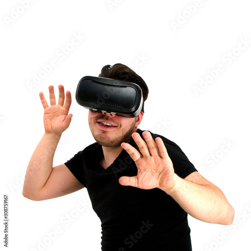 An isolated young man in a black tank top with black hair and a neat beard wearing new virtual reality glasses.The virtual world is very interesting, modern technology.Studio shot, white background
