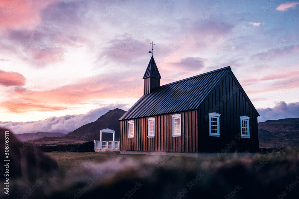 Fototapeta premium Kirche vor dramatischem Bergpanorama Island