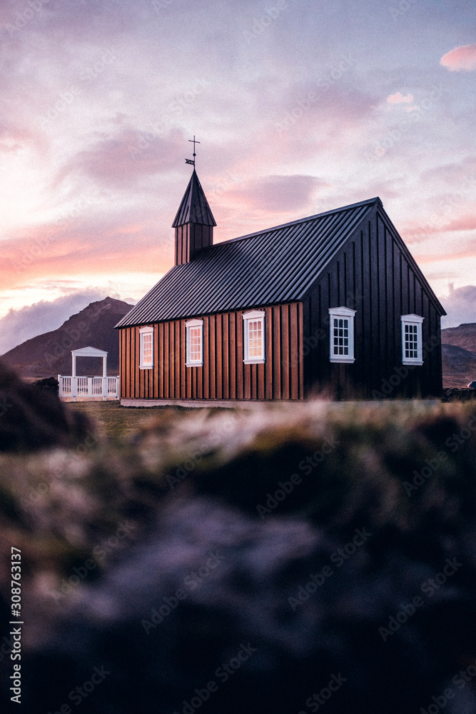 Fototapeta premium Kirche vor dramatischem Bergpanorama Island