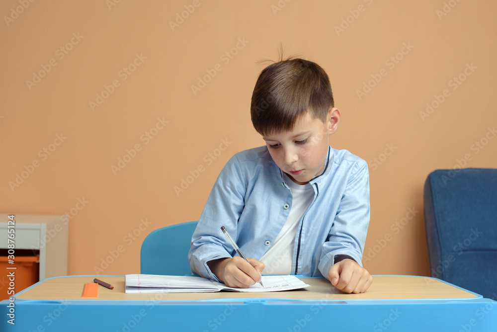 Home schooled boy doing his assignments. He is sitting at desk and solving difficult task. Home schooled boy doing his assignments. He is sitting at desk and solving difficult task.