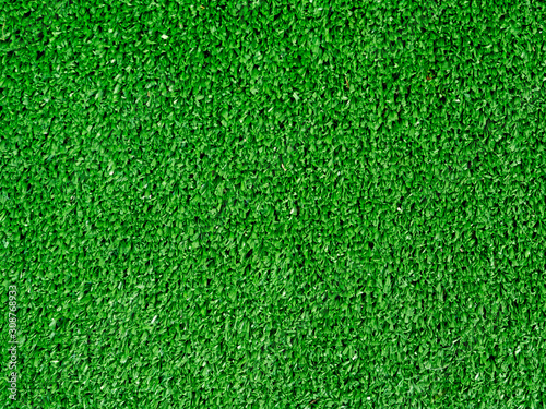Flat lay artificial grass made of green synthetic fibers. Top view evergreen lawn background