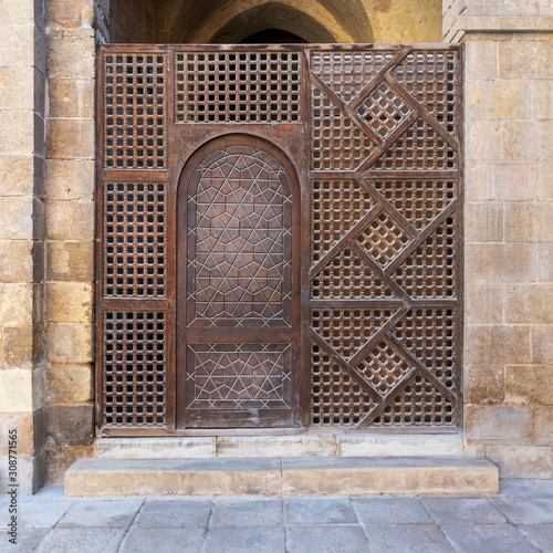 Interleaved wooden wall, known as mashrabiya, with wooden ornate door, Old Cairo, Egypt photo