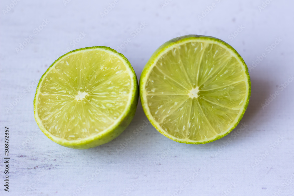 Fresh whole lemon and sliced lime on a white background. Fresh whole lemon and sliced lime on a white background.
