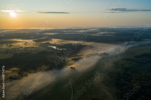 flight over the lake forest in a foggy summer sunny morning (photo from drone )