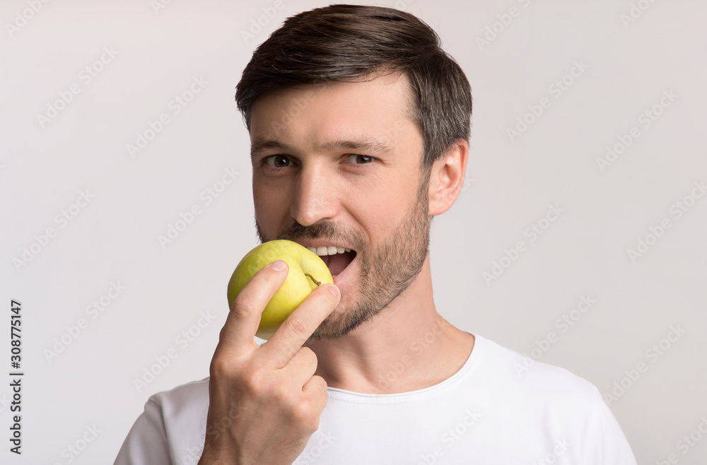 Happy Man Biting Apple Standing Over White Studio Background Happy Man Biting Apple Standing Over White Studio Background