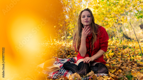 Incredible stunning girl in a red dress. The background is fantastic autumn. Artistic photography.