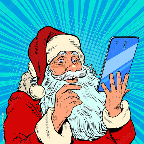 Santa Claus and a big smartphone. Electronic Christmas sales and orders in online stores