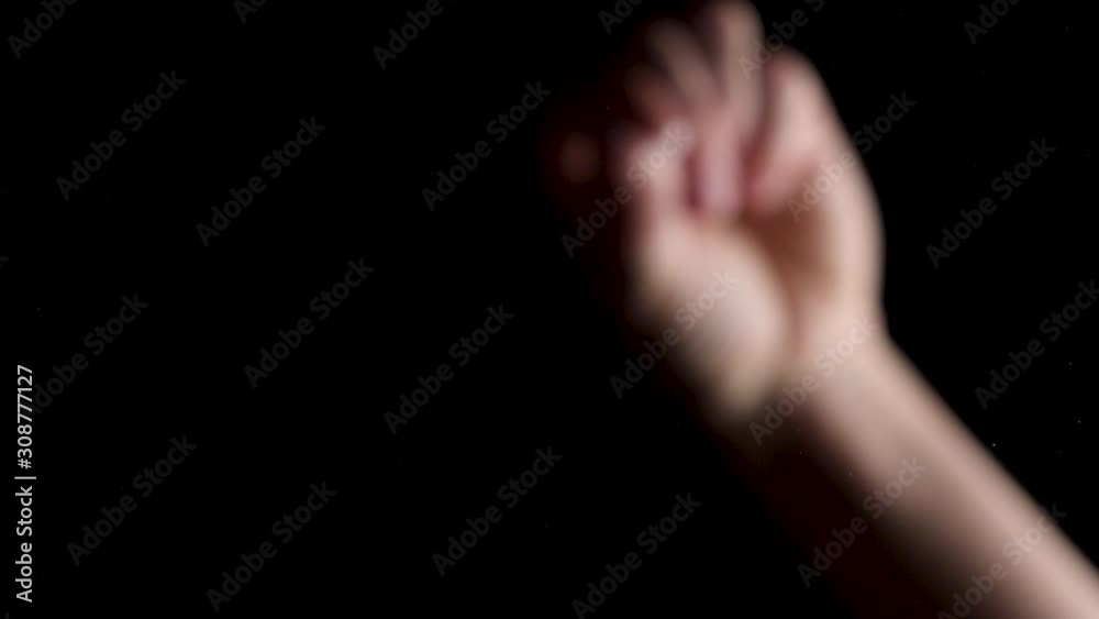 Grainy crystal glitter salt being sprinkled on glass on a black background Grainy crystal glitter salt being sprinkled on glass on a black background