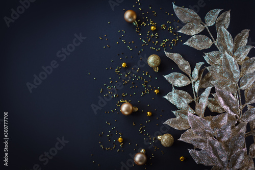 Fototapeta Naklejka Na Ścianę i Meble -  Golden Christmas decoration on dark background. Baubles and leaves.