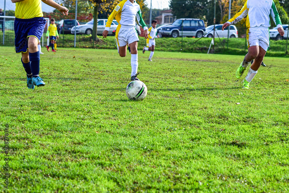 Obraz premium three young football players. Children play a soccer game. Legs in action with a ball.