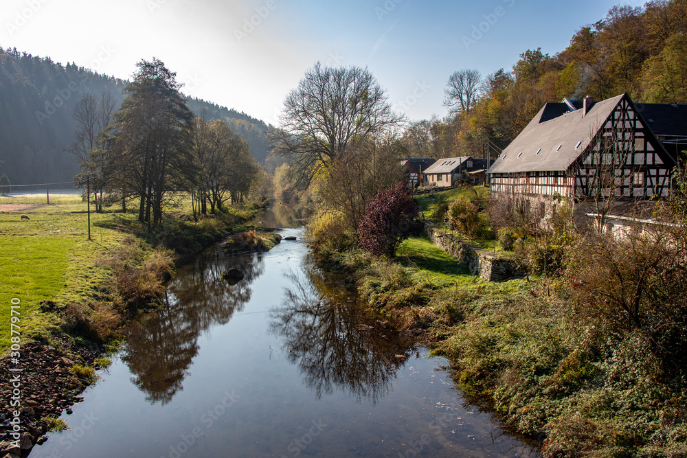 Romantic autumn landscape with river Elster with beautifully renovated old farm near the place Neumühle / Elster in Thuringia / Germany a beautiful hiking area