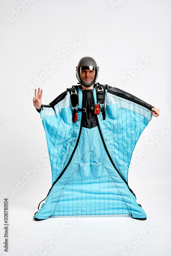 Three fingers. Men in wing suit show three fingers. Skydiving men in parashute. Simulator of free fall.
