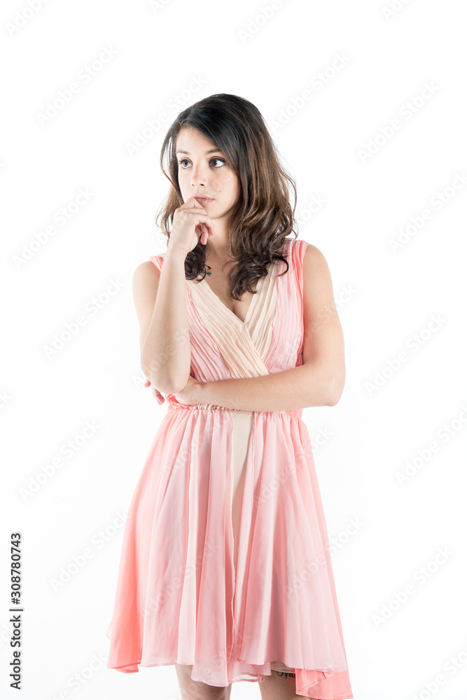 Isolated young woman on a pink dress while on deep thought