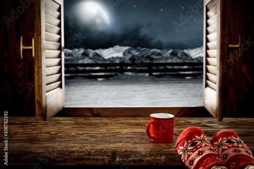 Woman legs with window sill and free space for your decoration.Christmas time and dark december night 