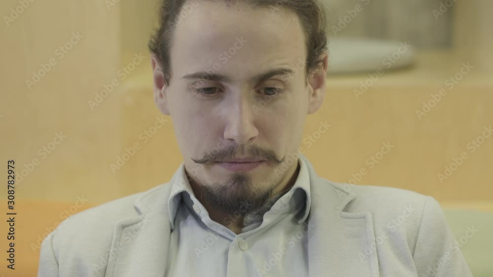 Close-up portrait of young Caucasian man with mustaches and beard looking at laptop. Positive businessman working online. Success, overworking, business, professional. Close-up portrait of young Caucasian man with mustaches and beard looking at laptop. Positive businessman working online. Success, overworking, business, professional.