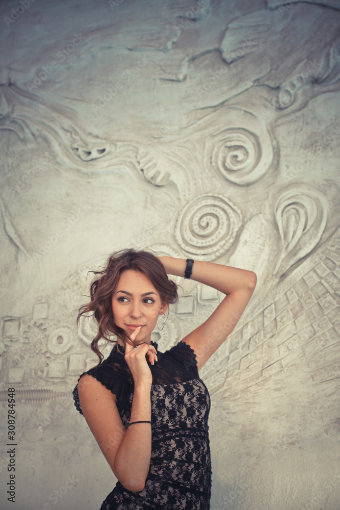 Portrait of a beautiful sexy woman with fashion makeup on face and long black hair. Glamour girl poses over relief creative background Portrait of a beautiful sexy woman with fashion makeup on face and long black hair. Glamour girl poses over relief creative background