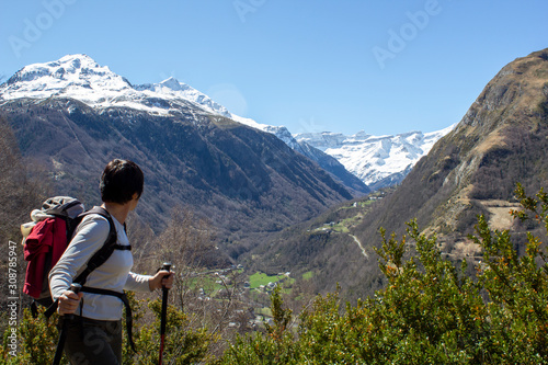 woman hiker admiring the cirque of Gavarnie snow-covered in the distance, the helmet and the breach of Roland © Marc