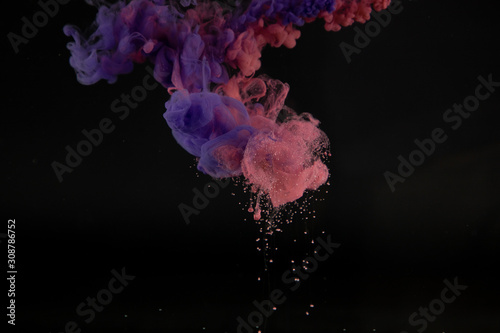 Acrylic colors in water with black background. Ink blot. Abstract background.