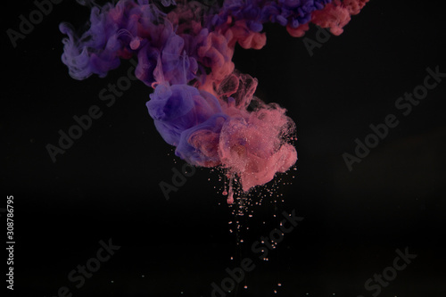 Acrylic colors in water with black background. Ink blot. Abstract background.