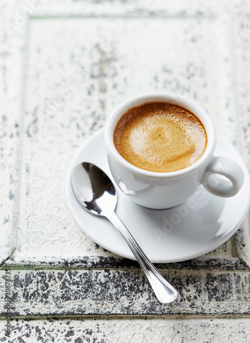 Cup of coffee on white wooden background. Close up. 