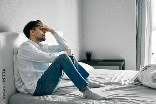 man sitting on sofa and using laptop