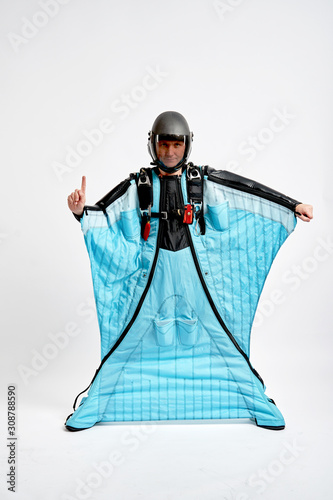 One finger. Men in wing suit show one finger. Skydiving men in parashute. Simulator of free fall.