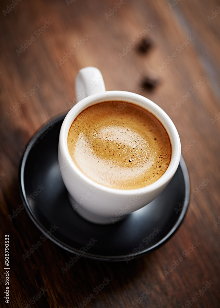 Fototapeta premium Cup of coffee with amaretti (Italian biscuit) on rustic wooden background. Close up.