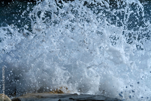 Sea wave splash on rocks background