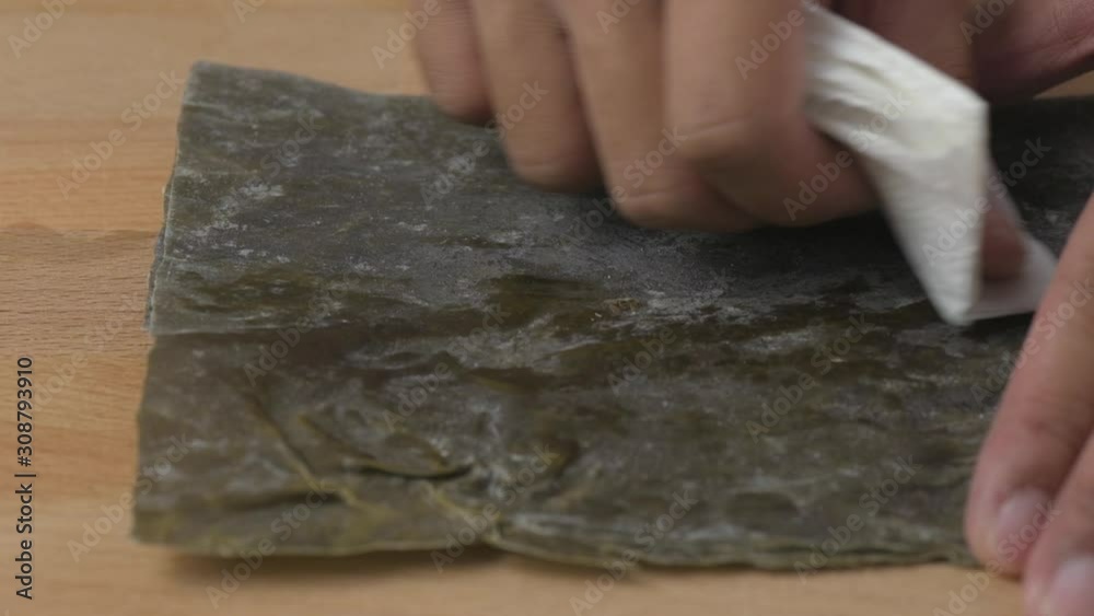 Wiping dry Japanese kombu seasweed with clean paper. Wiping dry Japanese kombu seasweed with clean paper.