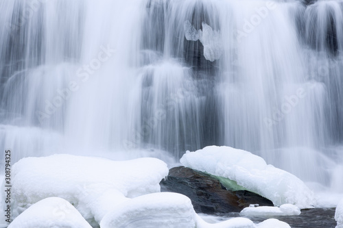 Winter  Bond Falls cascade captured with motion blur and framed by ice and snow  Michigan s Upper Peninsula  USA 