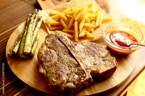 Porterhousesteak mit Pommesfrittes und Spargel photo