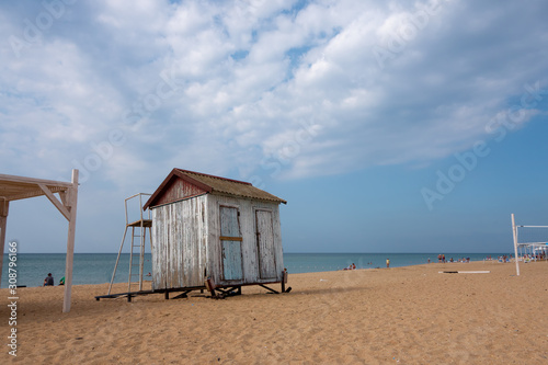 The empty beach on the sea in autumn with a small abandoned cloakroom. Cloudy sky in the afternoon © irinario
