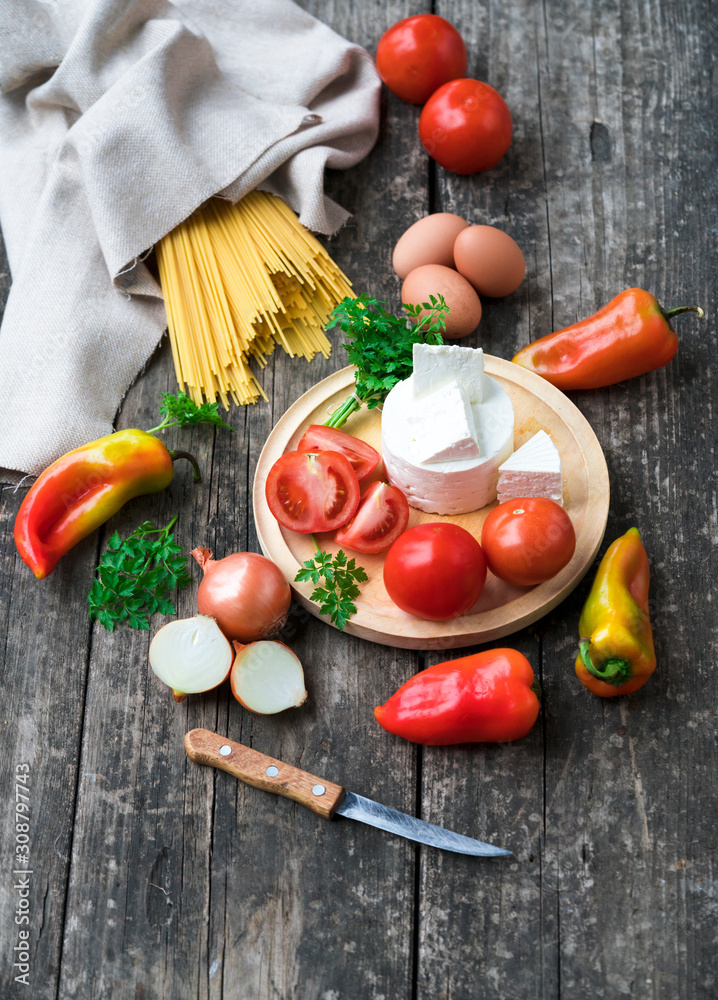 food ingredients - pasta, vegetables, cheese, eggs on a wooden background food ingredients - pasta, vegetables, cheese, eggs on a wooden background