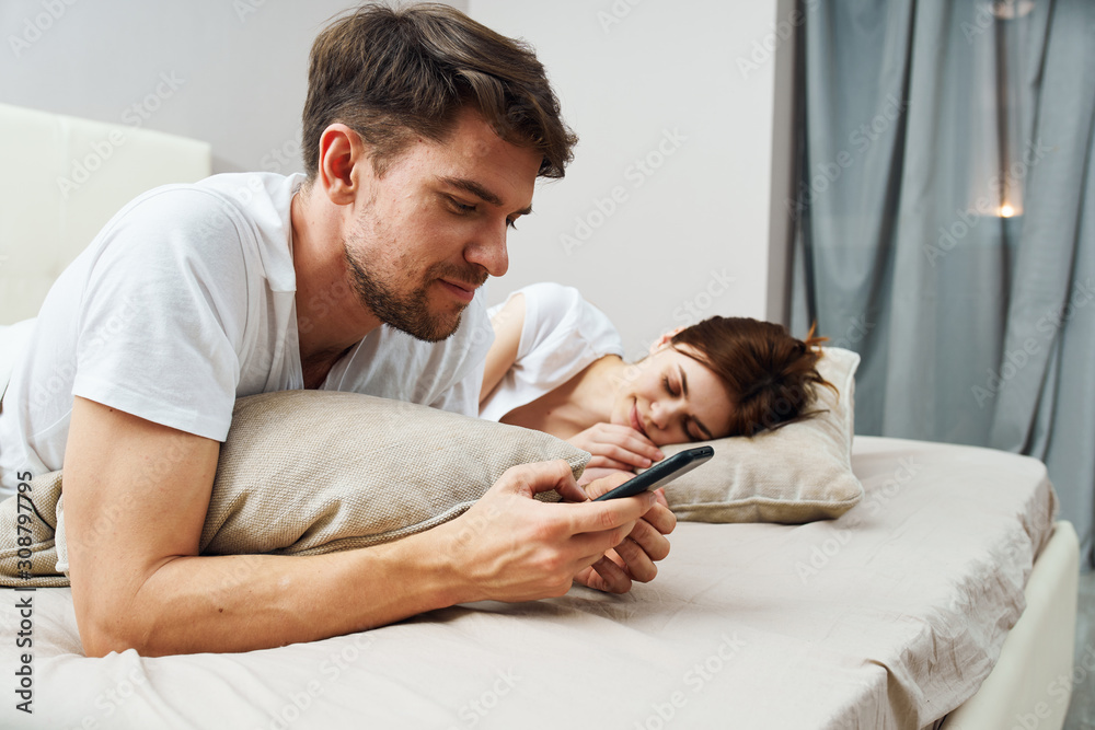 father and son watching tv in bed