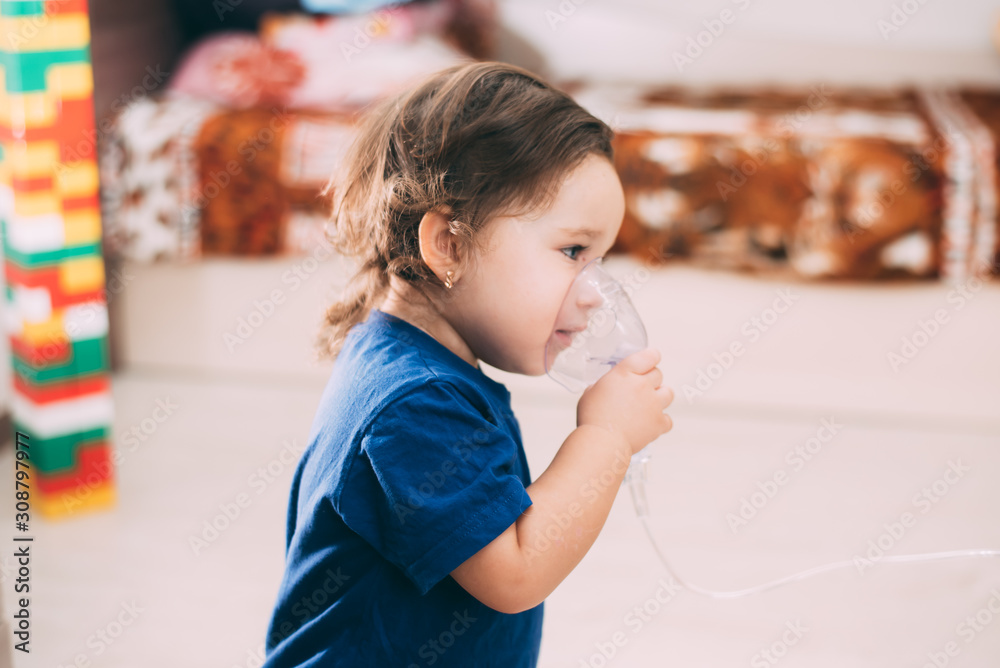a little girl yourself holding the mask of the nebulizer, making inhalation a little girl yourself holding the mask of the nebulizer, making inhalation