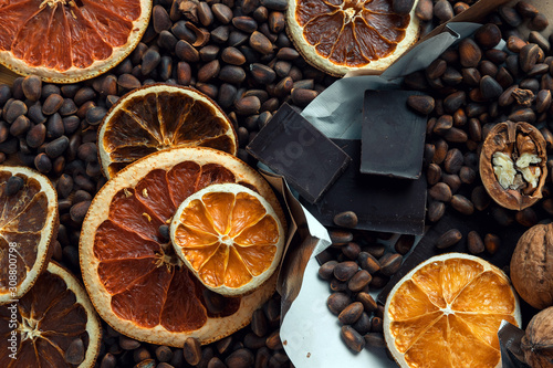 brown background of chocolate, nuts and dried citrus