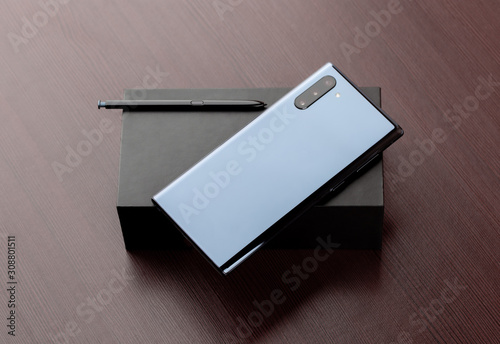 A smartphone with three cameras on a box close-up.
