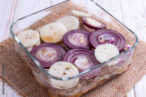 Marinated meat with onions and spices in a container photo