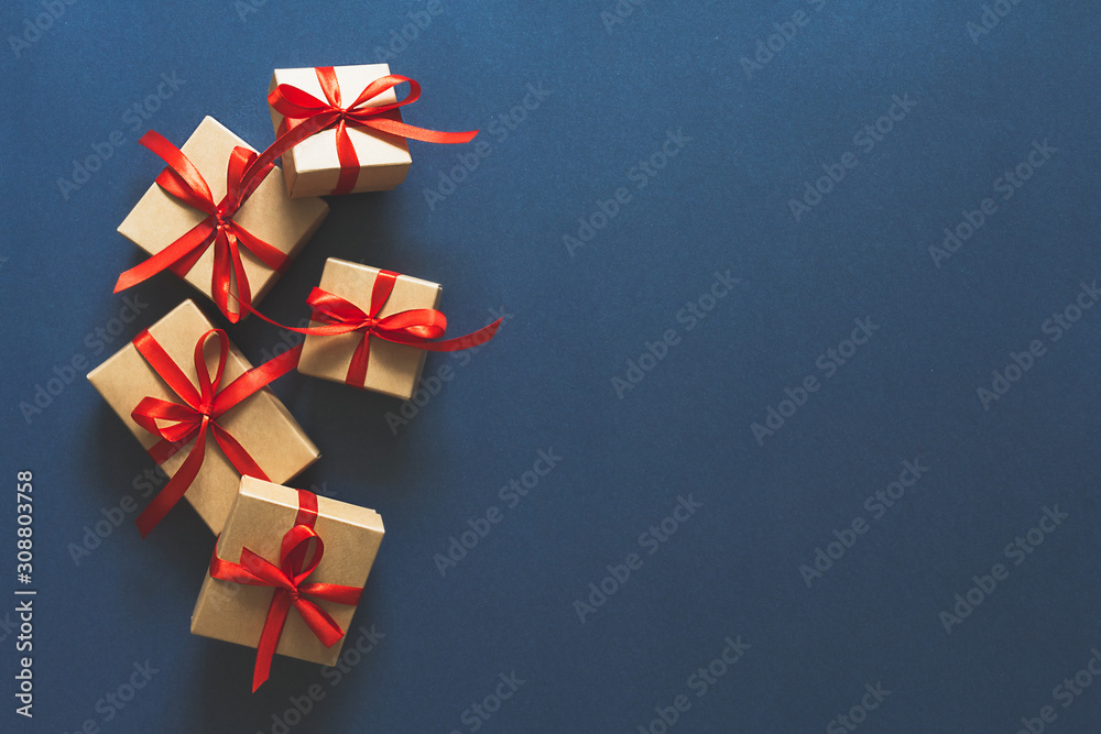 Christmas flat lay. Holiday gifts in boxes in craft paper and a red ribbon on a classic blue background 2020.Zero waste, Christmas eco-friendly gift wrapping gift wrapping concept, eco friendly banner Christmas flat lay. Holiday gifts in boxes in craft paper and a red ribbon on a classic blue background 2020.Zero waste, Christmas eco-friendly gift wrapping gift wrapping concept, eco friendly banner