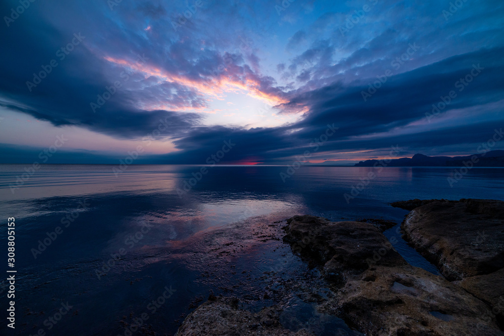 Beautiful sunset in blue clouds on the seashore