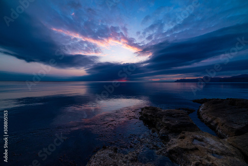 Beautiful sunset in blue clouds on the seashore