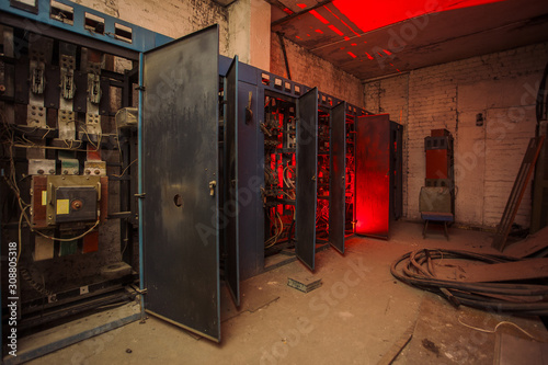 Switchgear cabinets with broken hardware in abandoned factory