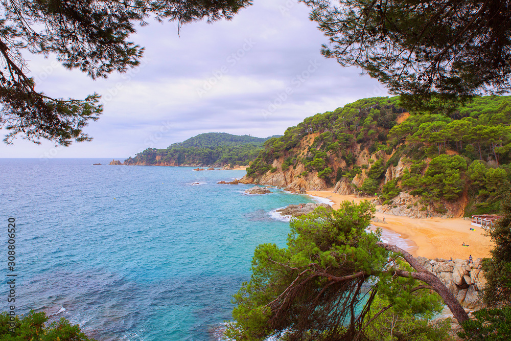 Seascape: blue sea with rocky shores and green trees. Lloret de Mar on a beautiful summer day, Costa Brava, Catalonia, Spain